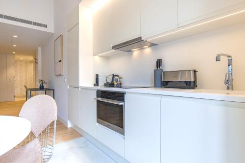 a kitchen with white cabinets and a counter top at Ando Living - Douradores House in Lisbon