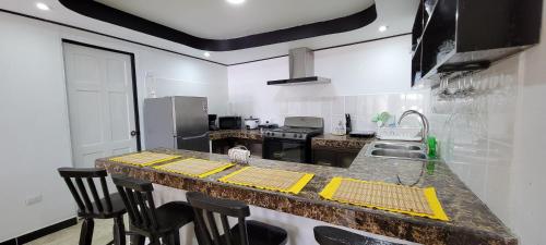 une cuisine avec un comptoir recouvert de tapis jaunes dans l'établissement Panda House, à Quepos