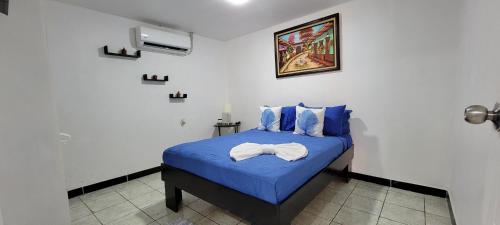 a bedroom with a blue bed with blue sheets at Panda House in Quepos