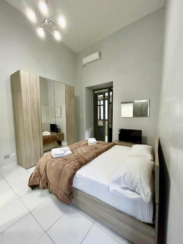 una camera con un grande letto e uno specchio di B&B VALENTINO NAPOLI a Napoli