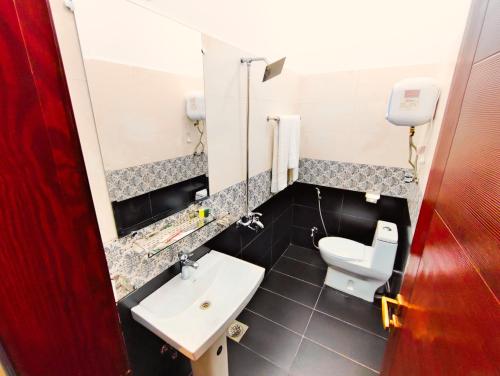 a bathroom with a white sink and a toilet at Hotel Nova in Lahore