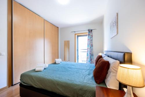 een slaapkamer met een groot bed en een raam bij Apartment Baixa Marina in Olhão