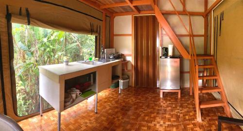 um quarto com uma cozinha, um lavatório e uma escada em Cabaña equipada em Puerto Jiménez