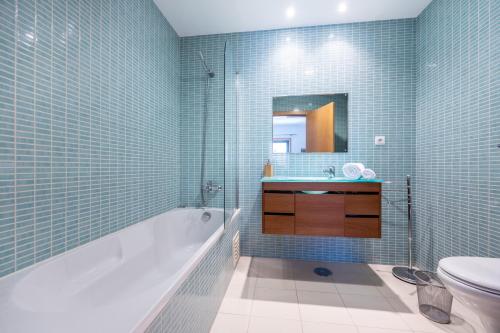 ein Badezimmer mit einer Badewanne, einem Waschbecken und einem WC in der Unterkunft Apartment Baixa Marina in Olhão
