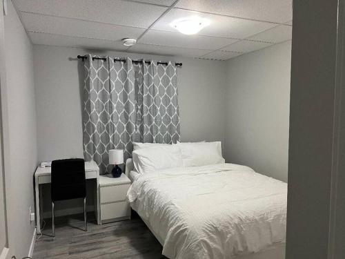 sypialnia z łóżkiem i biurkiem z krzesłem w obiekcie Cozy Modern and Lavish 3 Bedroom Basement Suite w mieście Winnipeg