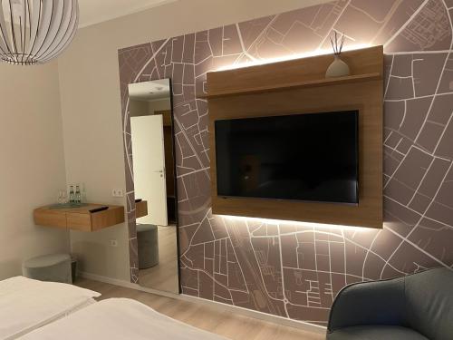 a bedroom with a flat screen tv on a wall at Hotel-Restaurant Haselhoff in Coesfeld