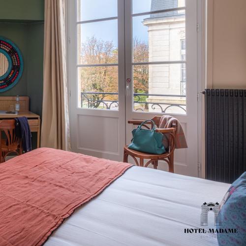 Un ou plusieurs lits dans un hébergement de l'établissement Hôtel Madame
