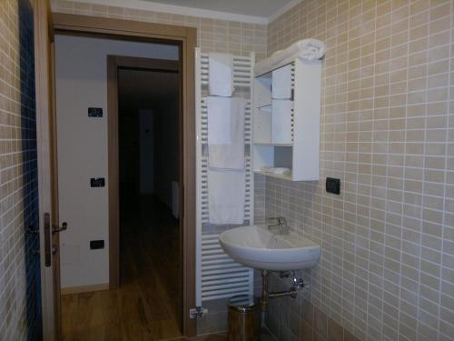 W łazience znajduje się umywalka i lustro. w obiekcie Hotel Al Prato w mieście Tonezza del Cimone