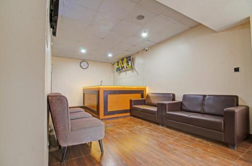 Habitación con sofá, TV y sillas. en I Care With Greenery Comforts, en Devanhalli