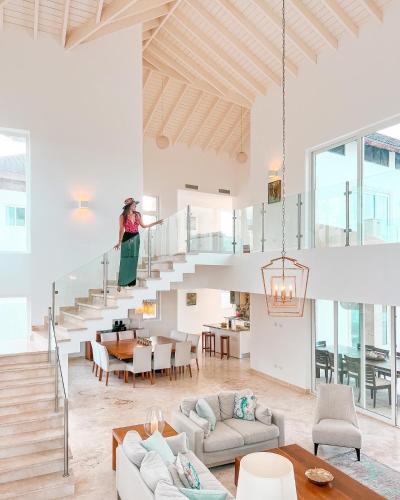 a woman is standing on the stairs in a living room at Peninsula Esmeralda Luxury Villas in San Felipe de Puerto Plata