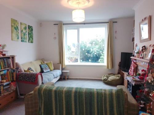 a living room with a couch and a window at Beautiful family home in Taffs Well