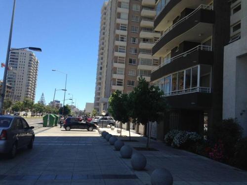 比尼亞德爾馬的住宿－Departamento en centro de Viña del Mar，一条城市街道,汽车停在大楼前