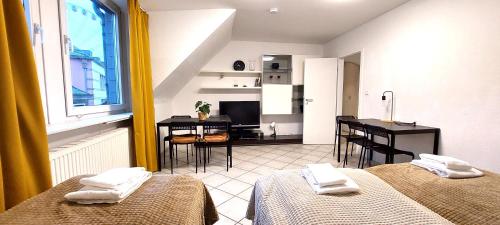 a room with two beds and a table and a kitchen at Old Town 2 Room Apartments in Düsseldorf