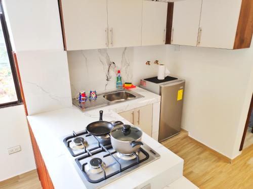 a kitchen with a stove with two pots on it at Pacific Suites Guayaquil Airport in Guayaquil