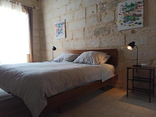 QormiにあるBeautiful Studio apartment in Qormi Maltaのレンガの壁、ベッド付きのベッドルーム1室