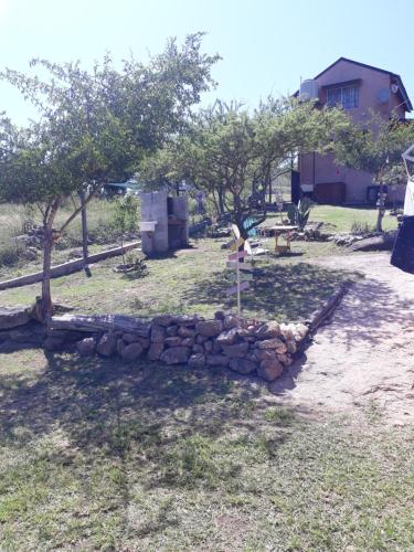 einen Haufen Steine in einem Garten mit Bäumen in der Unterkunft Cabañas Dulce Atardecer in Villa Carlos Paz