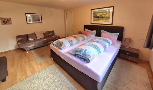 - une chambre avec un lit avec des oreillers et un canapé dans l'établissement Landhaus Ostermann, à Umhausen