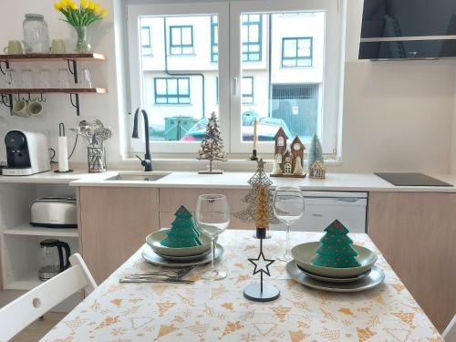 a kitchen table with two wine glasses and christmas trees on it at Apartamentos Playa de Finisterre in Fisterra