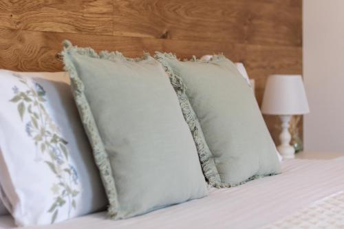 a pile of pillows on a bed with a wooden headboard at Agriturismo Fondo Gioconda in Marcon