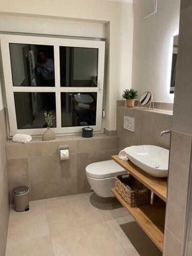 La salle de bains est pourvue de toilettes, d'un lavabo et d'une fenêtre. dans l'établissement Hotel-Restaurant Haselhoff, à Coesfeld