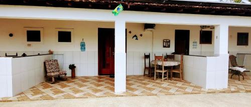a porch of a house with a table and chairs at Suítes Ninho da Águia Saquarema in Saquarema