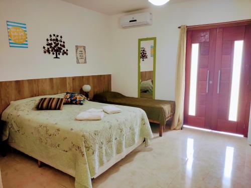 a bedroom with a bed and a red door at Suítes Ninho da Águia Saquarema in Saquarema