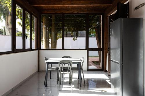 una sala da pranzo con tavolo, sedie e frigorifero di Luxury Villa Ebe a Palermo
