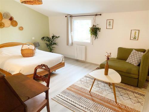 un soggiorno con letto e divano di L'Autre Rivière - Chambres d'hôtes a Ducey