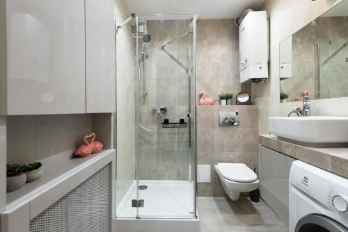 a bathroom with a shower and a toilet and a sink at Apartament Chopin - ścisłe centrum - by Kairos Apartments in Gliwice