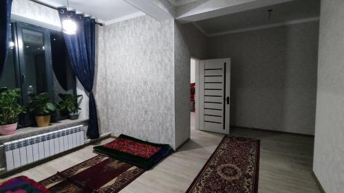 a room with a door and a rug and a window at Tündük Guest House, Karakol in Karakol