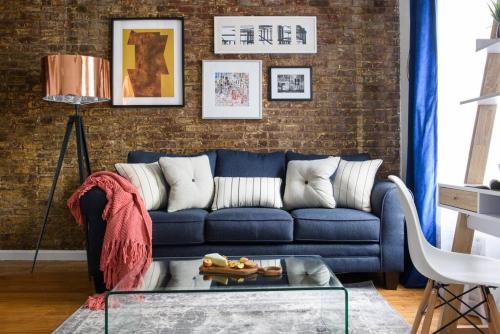 sala de estar con sofá azul y pared de ladrillo en 26-3B 1BR prime gramercy WD in unit Courtyard, en Nueva York