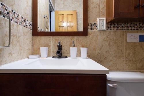 een badkamer met een wastafel, een toilet en een spiegel bij 26-3B 1BR prime gramercy WD in unit Courtyard in New York