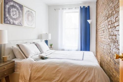 ein Schlafzimmer mit einem Bett und einer Ziegelwand in der Unterkunft 26-3B 1BR prime gramercy WD in unit Courtyard in New York