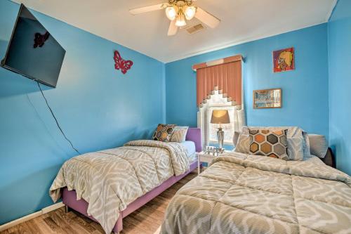 two beds in a bedroom with blue walls at Eclectic Chicago Apartment with Spacious Deck! in Chicago