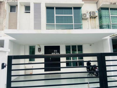 una casa bianca con una recinzione nera davanti di I-STAY 01 JK Roomstay a Kampong Bemban