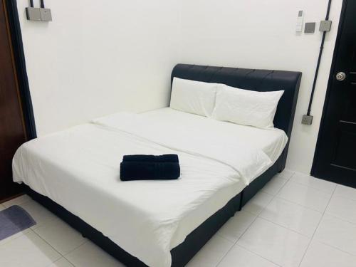 I-STAY 01 JK Roomstay في Kampong Bemban: سرير مع كيس اسود جالس عليه