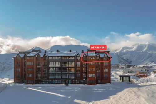 a building in the snow with a sign on it at 4-Bedroom Luxury Apartment in New Gudauri in Gudauri