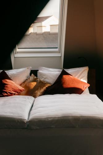 a bed with pillows sitting next to a window at WELTWIEN Luxury Art Apartments & Free Parking in Vienna