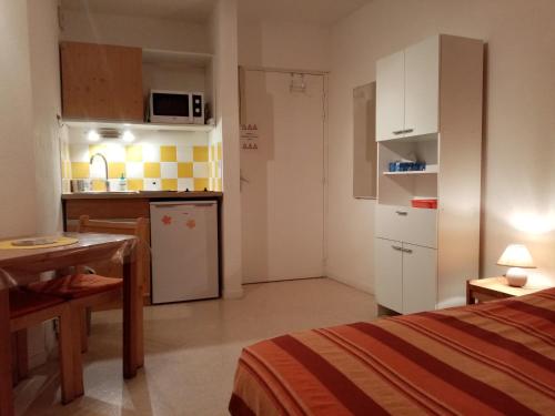 Ce petit appartement dispose d'une cuisine, d'une table et d'une chambre. dans l'établissement Studio "Le Rigaou", à Gréoux-les-Bains