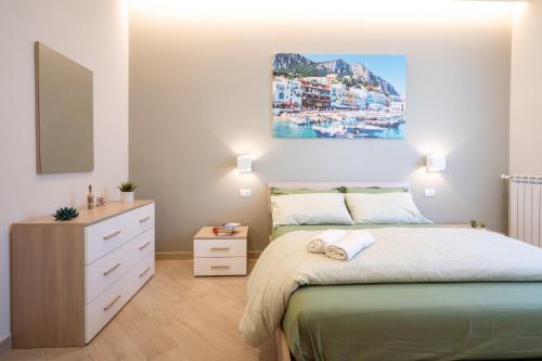1 dormitorio con 1 cama y una pintura en la pared en Casa Ventidue en Sant'Agnello