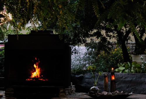 a fireplace with a fire in it in a yard at EXQUISITE PRIVATE LUXURY SUITE WITH KING BED at BOKMAKIERIE VILLAS in Windhoek