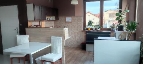 eine Küche mit einem weißen Tisch und Stühlen in einem Zimmer in der Unterkunft Noclegi Centrum in Jelenia Góra