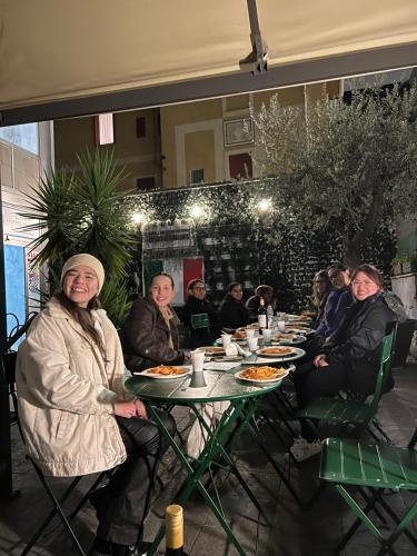 a group of people sitting at a table eating food at Lion University & Youth Hostel Milano in Milan
