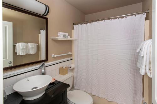a bathroom with a white shower curtain and a sink at Cannon Beach Hotel Collection in Cannon Beach