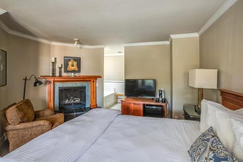 a bedroom with a bed and a fireplace and a television at Cannon Beach Hotel Collection in Cannon Beach