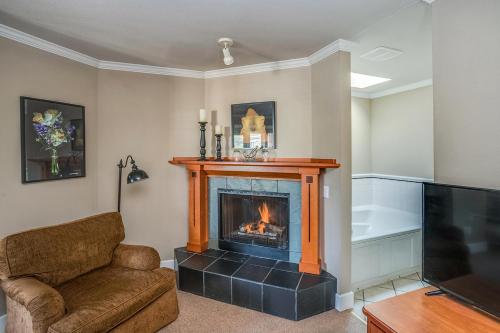 a living room with a fireplace and a couch and a television at Cannon Beach Hotel Collection in Cannon Beach
