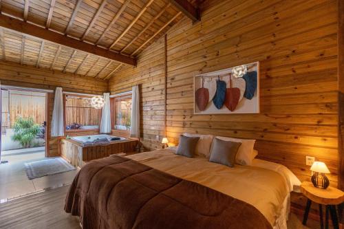 een slaapkamer met een bed in een blokhut bij Pousada Canto da Nascente in Monte Verde