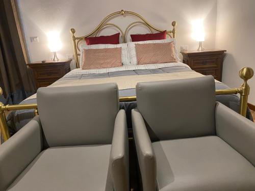 een slaapkamer met een bed met 2 stoelen en 2 lampen bij Il Rustico in Sansepolcro