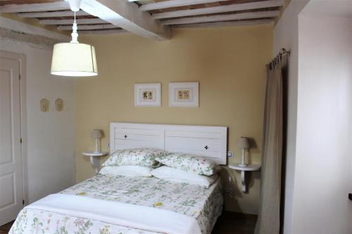 グッビオにあるRomantic Suiteのベッドルーム1室(ベッド1台、テーブル2台、ランプ付)