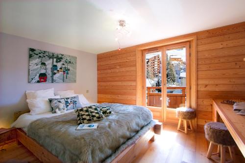 a bedroom with a bed and a desk and a window at Appartement Noel Martin - 3 chambres in Les Deux Alpes